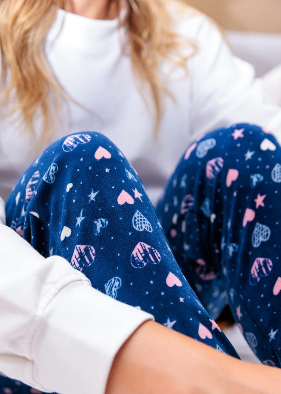 PJ joggers with soft velvety texture, stretch, elastic waistband, drawstring, and stylish ankle cuff. This pattern is a light blue, light pink hearts and starts on a navy background. It features a pink drawstring.