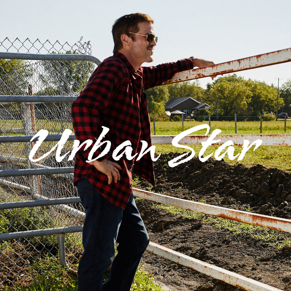 Click here to see Urban star product. Picture of a man leaning over a fence, in a rustic setting.
