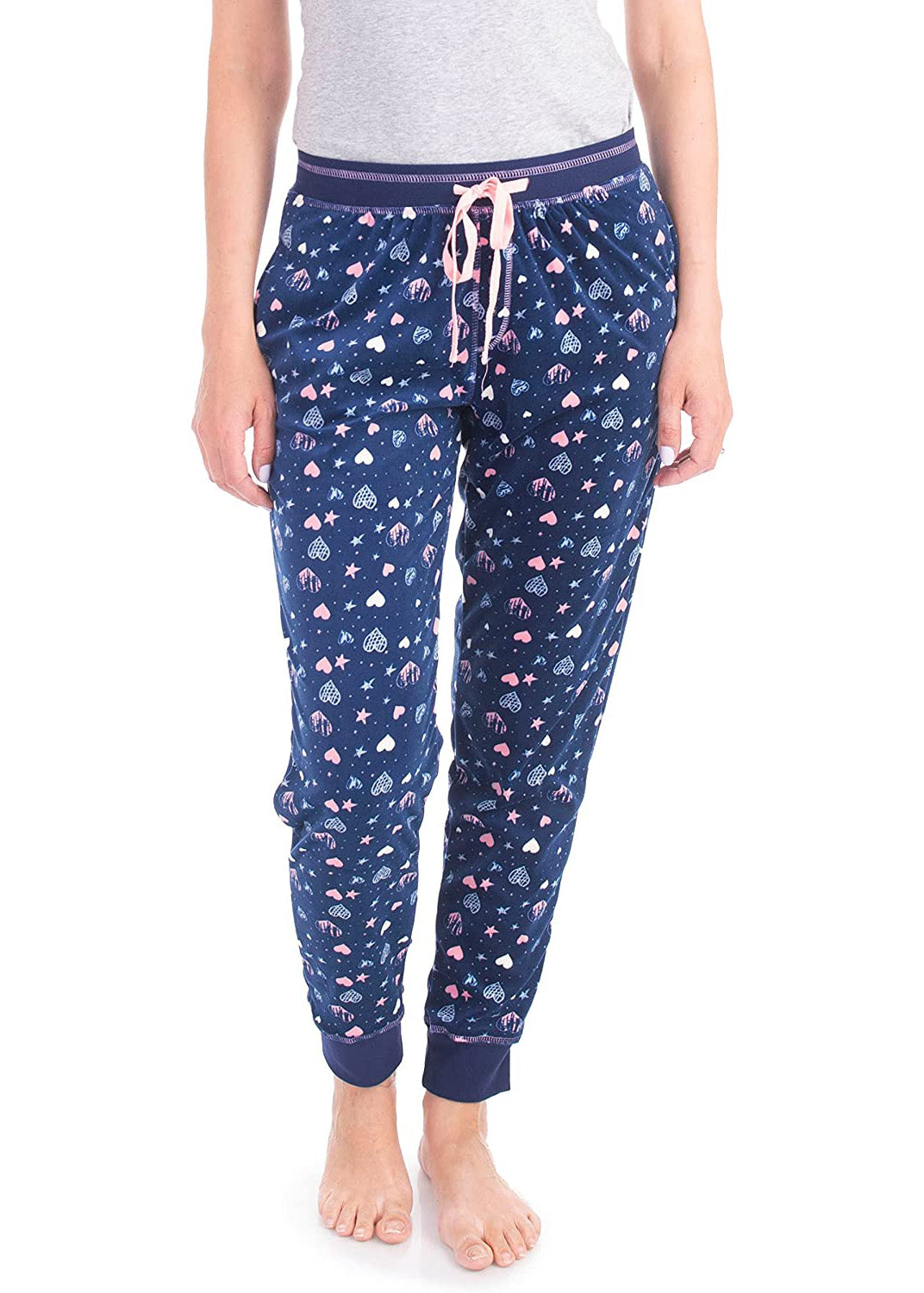 PJ joggers with soft velvety texture, stretch, elastic waistband, drawstring, and stylish ankle cuff. This pattern is a light blue, light pink hearts and starts on a navy background. It features a pink drawstring.